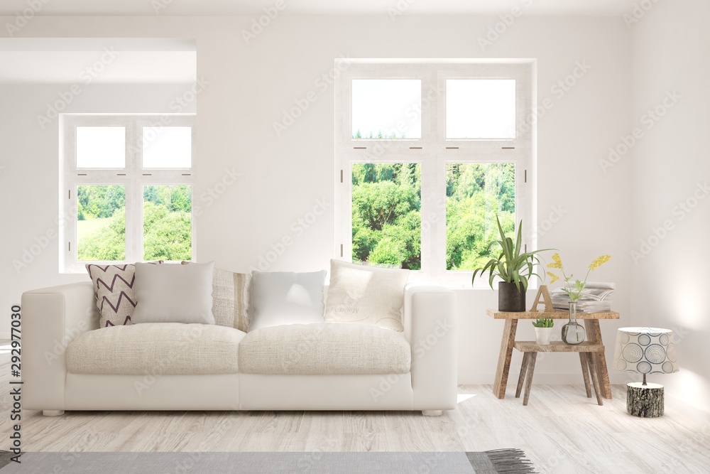 Stylish room in white color with sofa and summer landscape in window. Scandinavian interior design. 