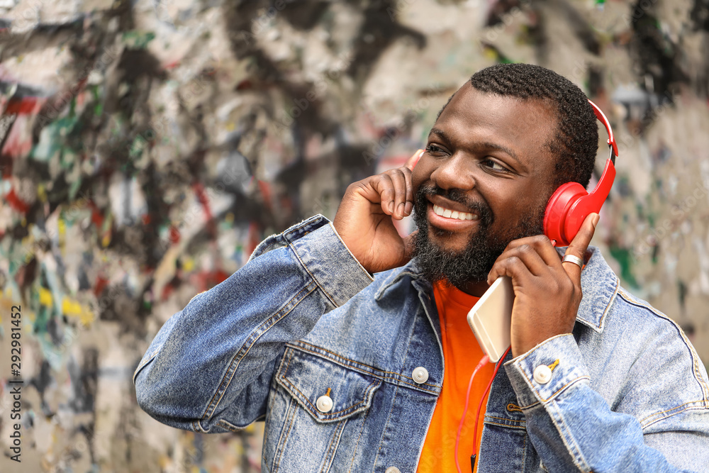 Handsome African-American man listening to music outdoors