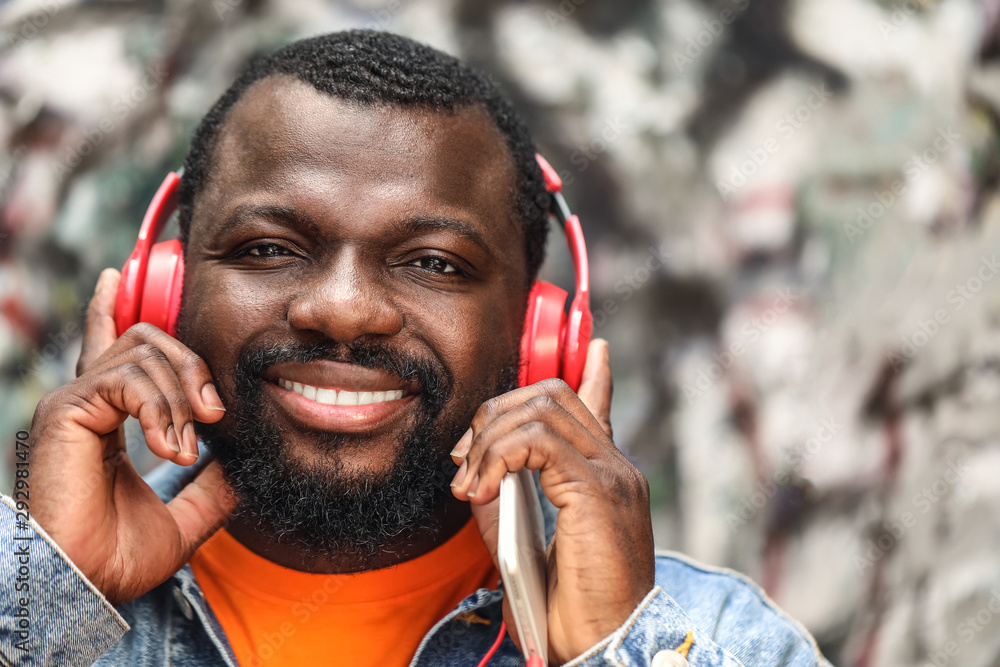 Handsome African-American man listening to music outdoors