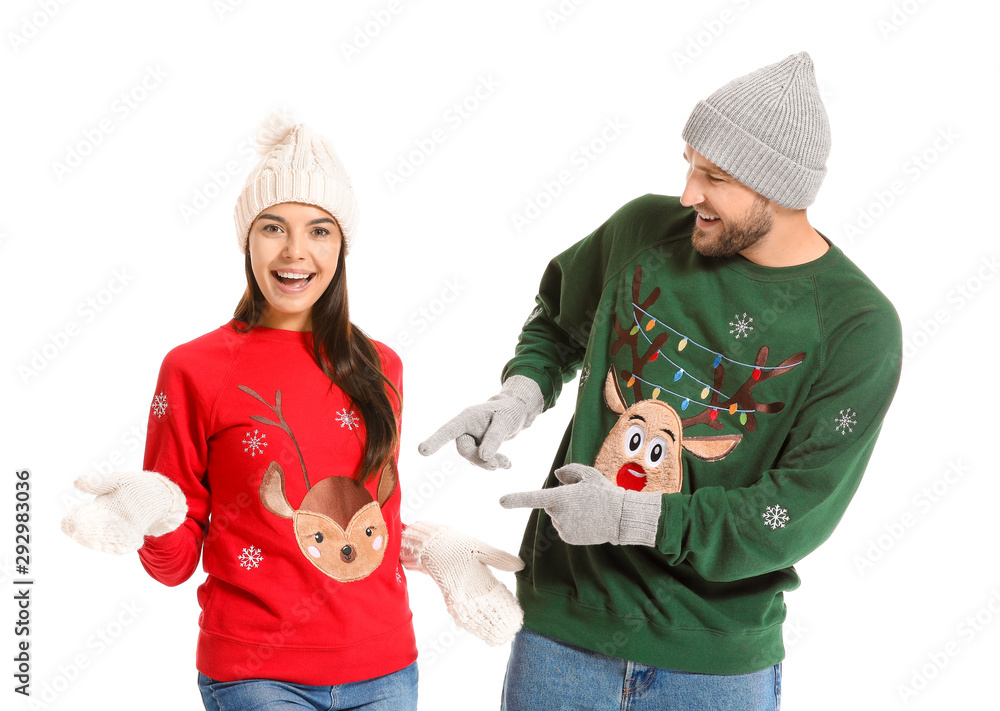 Young couple in Christmas sweaters on white background