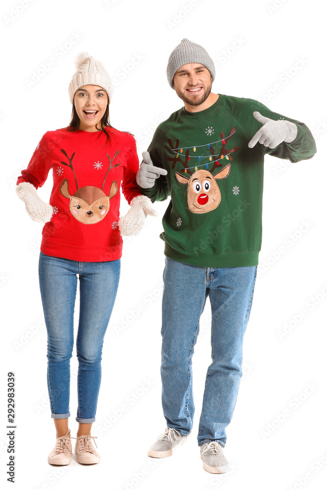 Young couple in Christmas sweaters on white background