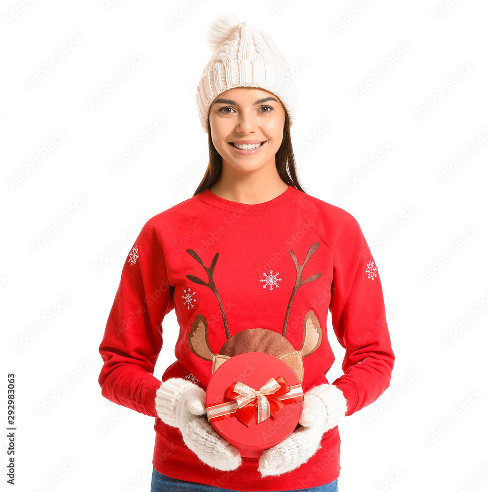 Young woman in Christmas sweater and with gift on white background