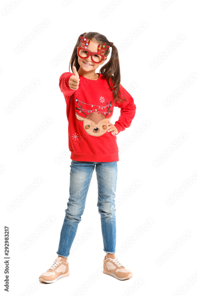 Little girl in Christmas sweater showing thumb-up on white background