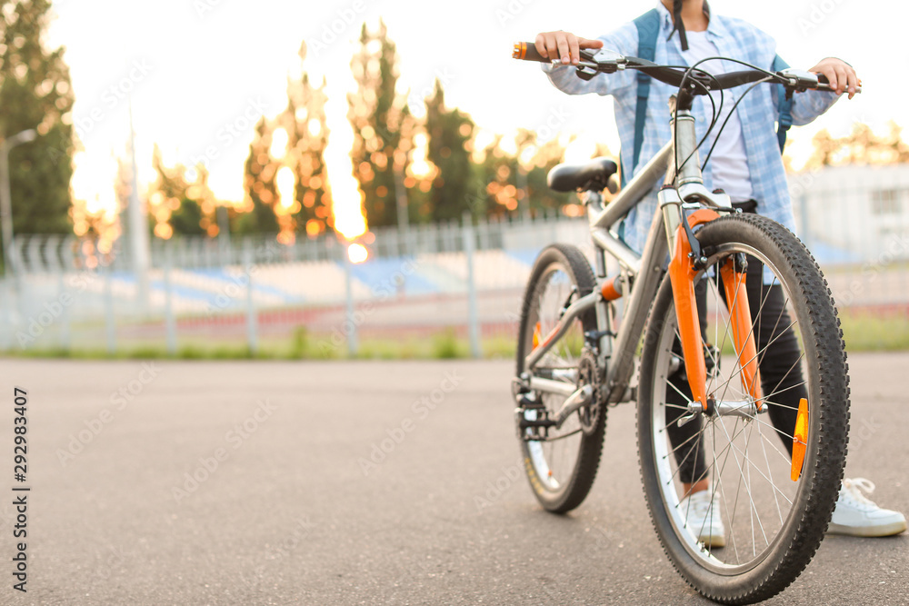 Cute boy riding bicycle outdoors