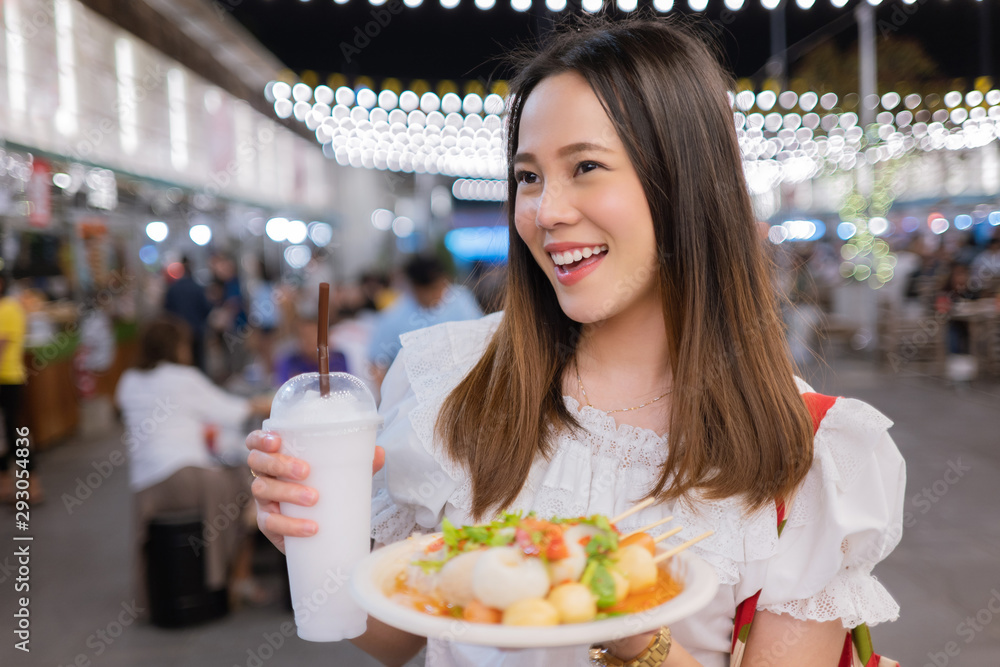 亚洲女游客晚上在泰国吃街头美食