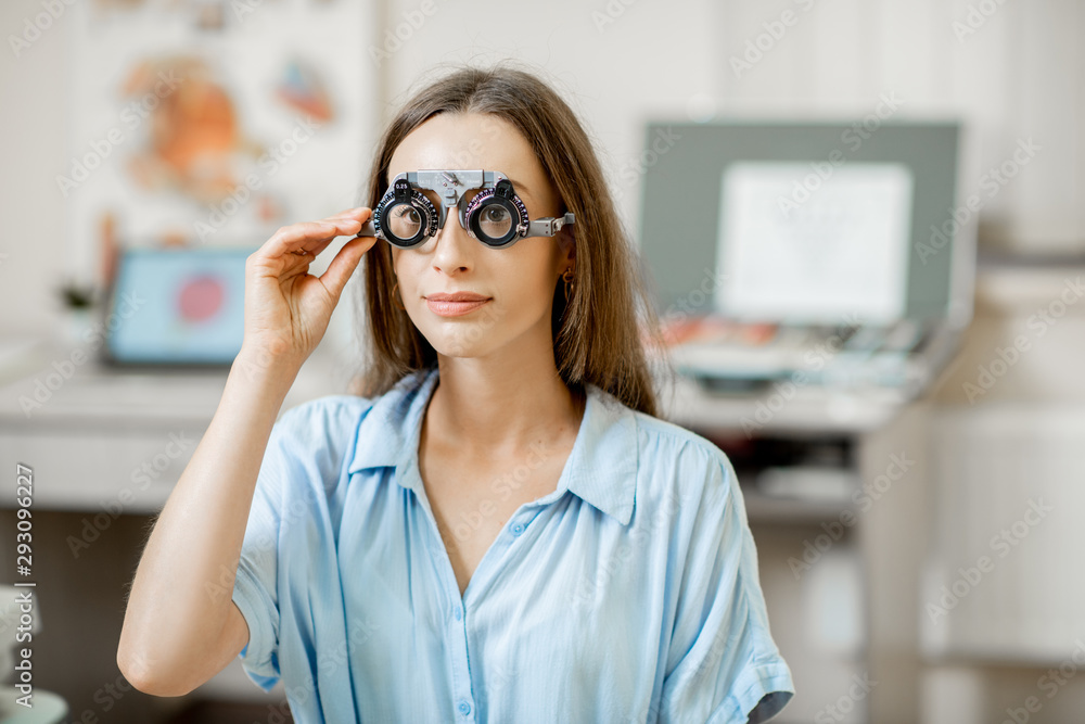 Young woman checking vision with eye test glasses during a medical examination at the ophthalmologic