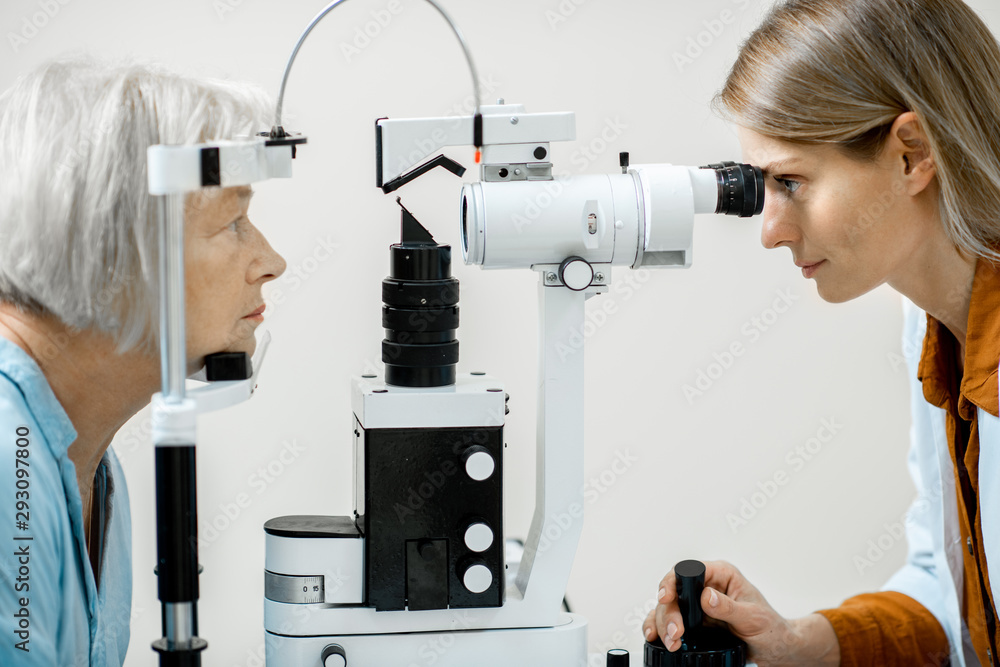 Ophthalmologist examining eyes of a senior patient using microscope during a medical examination in 