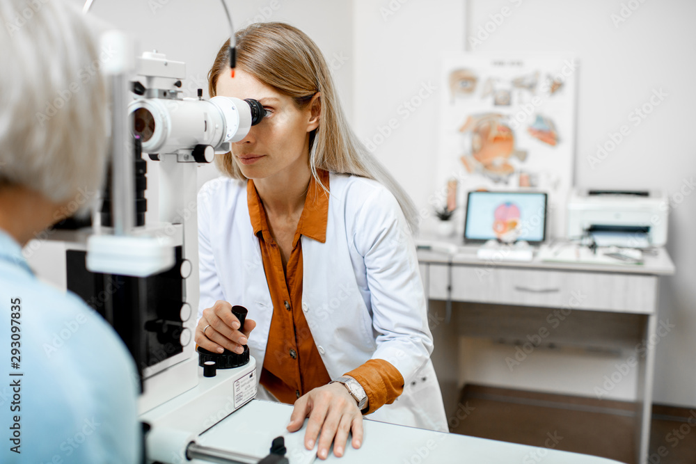 Ophthalmologist examining eyes of a senior patient using microscope during a medical examination in 