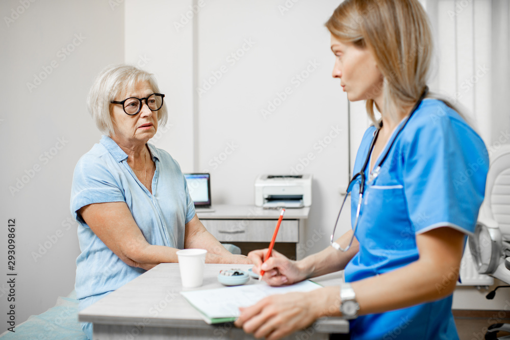 Nurse writing medical history recipe for a senior woman patient during a medical consultation in the