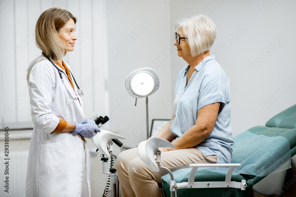 Senior woman sitting on the gynecological chair during a medical consultation with gynecologist. Con