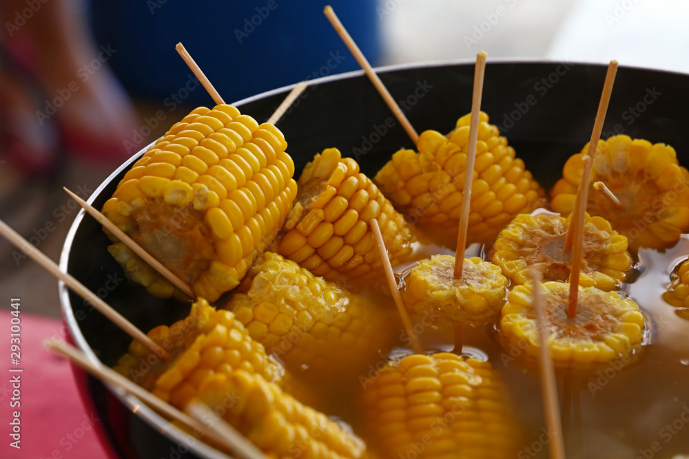 Closeup boiled cooked corn cobs on stick