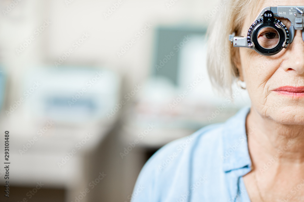 Close-up of a senior woman checking vision with eye test glasses during a medical examination at the