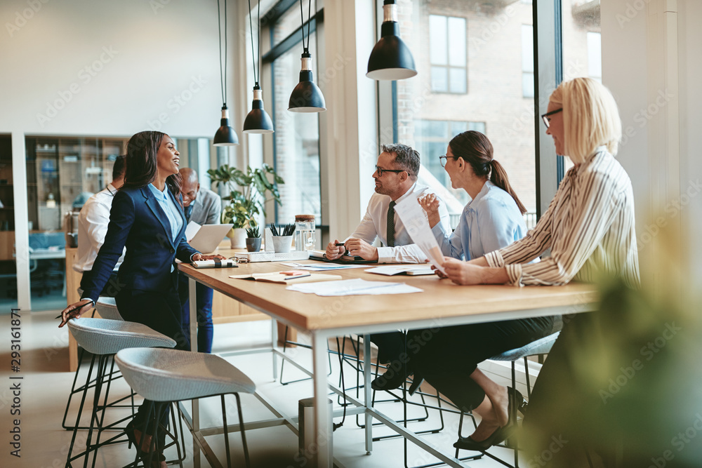 Smiling group of diverse businesspeople talking together around