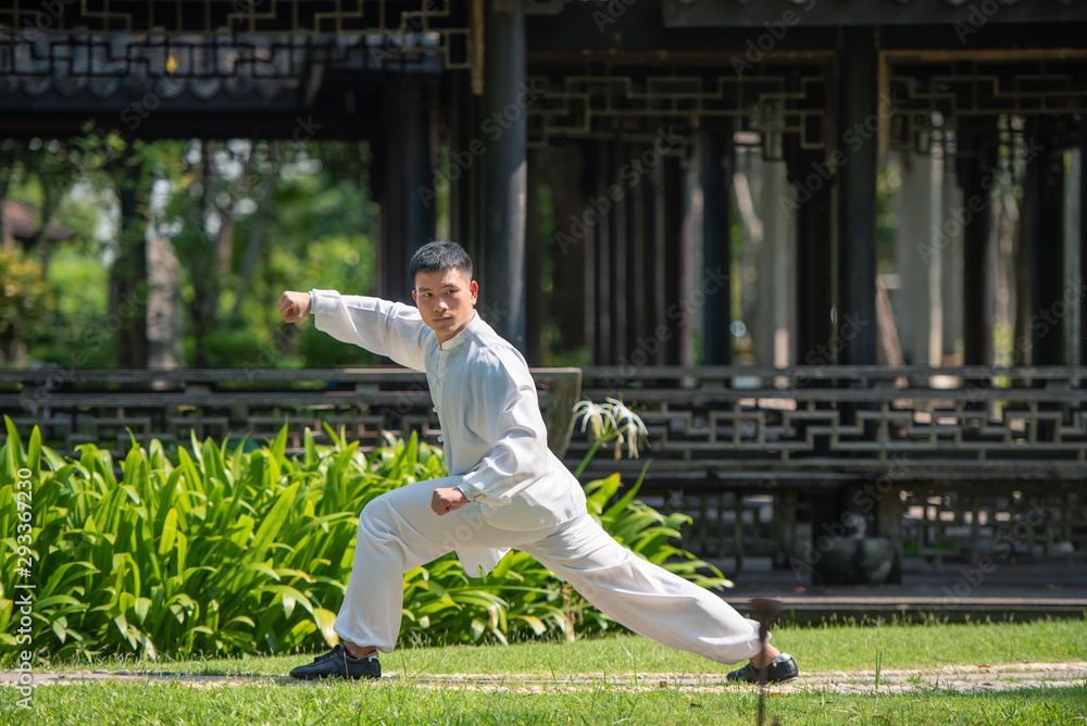 Asian man working out with Tai Chi in the morning at the park, Chinese martial arts, healthy care fo