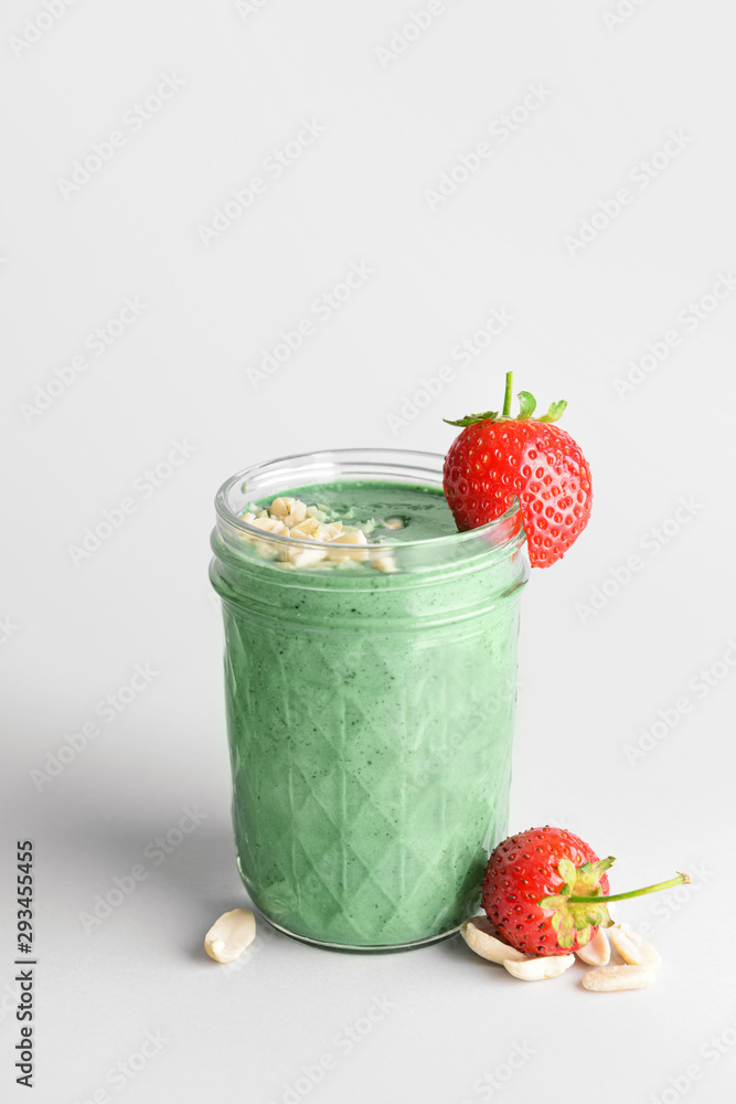 Glass of healthy spirulina smoothie on color background