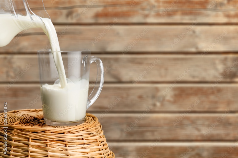 Glass jug of fresh milk  on background