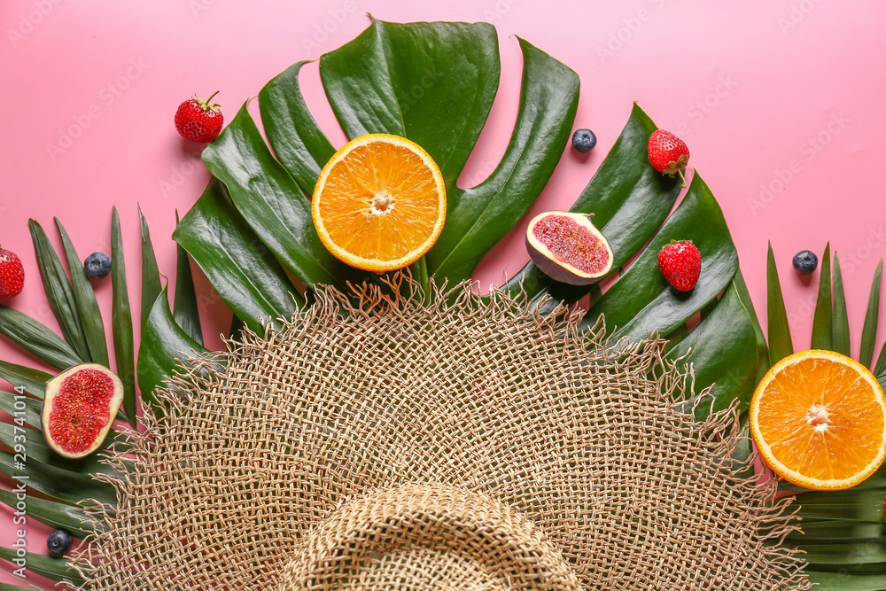 Summer composition with tropical fruits, leaves and hat on color background