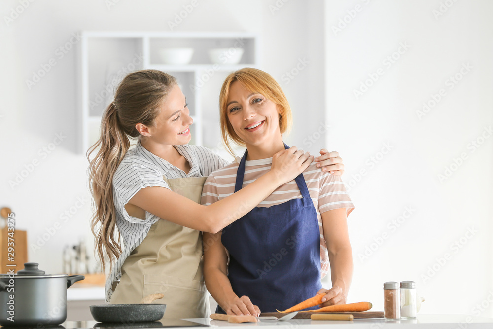 Young woman and her mother cooking together in kitchen