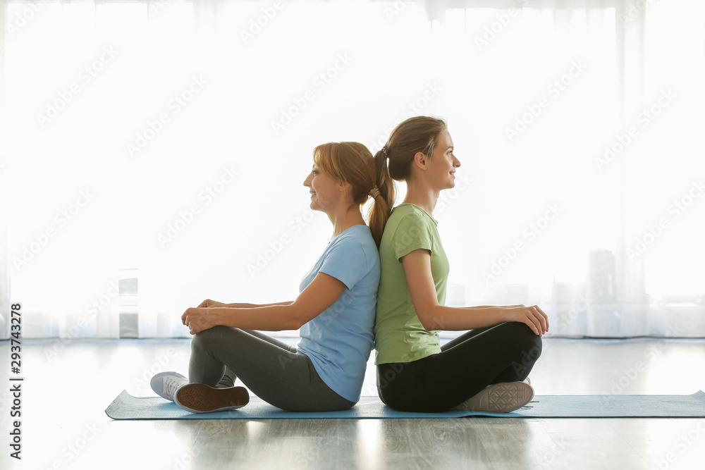 Mother and daughter practicing yoga at home