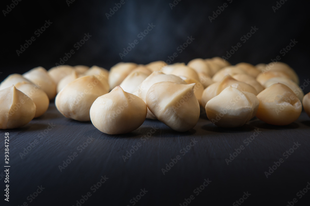 close up of dried macadamia nut on the black table with dark background