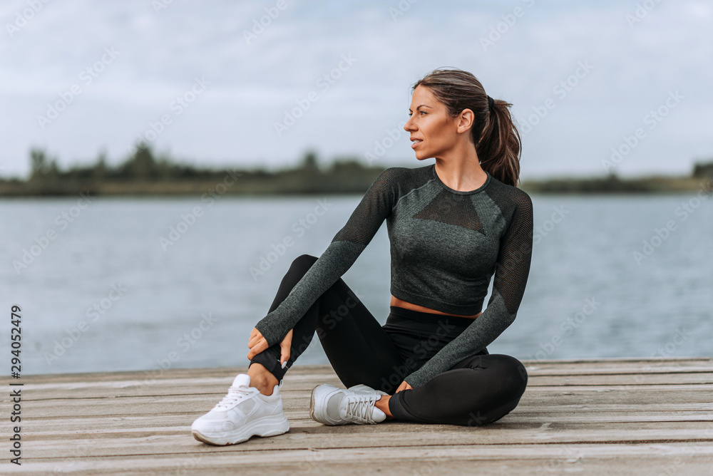 Portrait of female athlete relaxing after workout by the river.