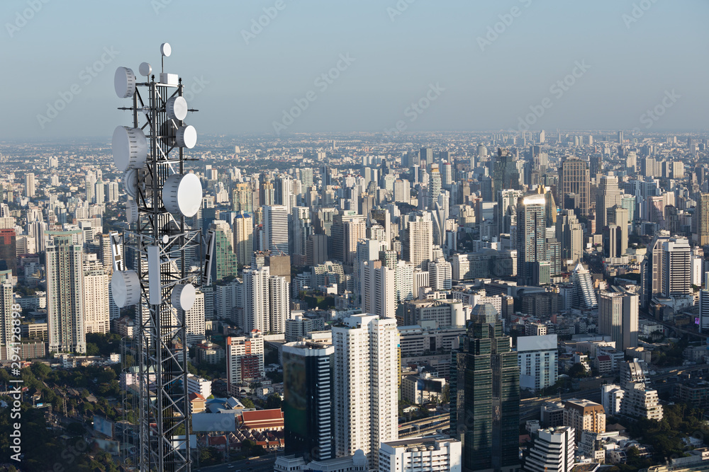 Telecommunication tower with 5G cellular network antenna on city background