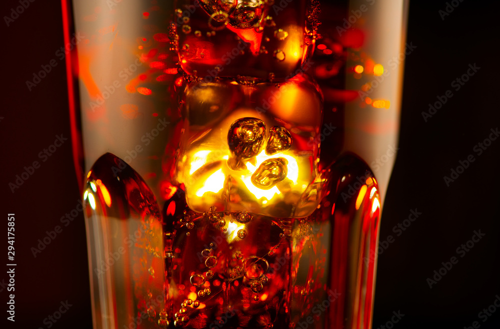 Fizzy Cola with ice cubes background. Coke drink with Ice, bubbles un a glass glass. Soda closeup ov