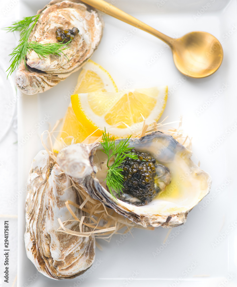 Fresh oysters with black caviar. Opened oysters with black sturgeon caviar and lemon, Gourmet food i