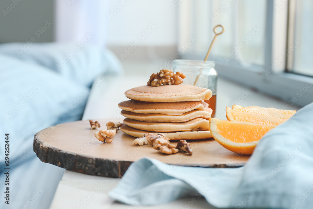 Tray with tasty breakfast on window sill in bedroom