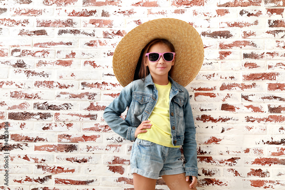 Cute fashionable girl against brick wall