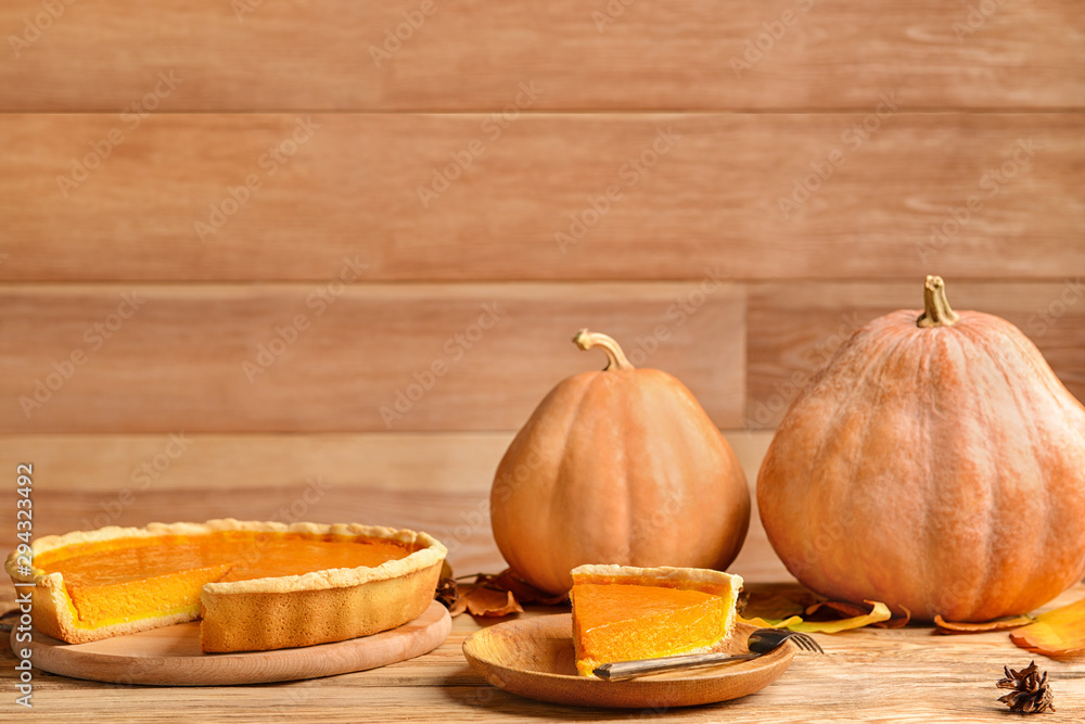 Composition with tasty pumpkin pie on wooden table