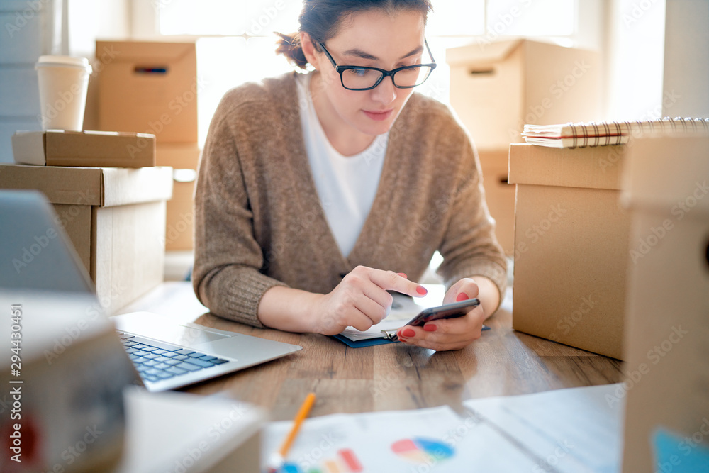 Woman is working at warehouse for online store.