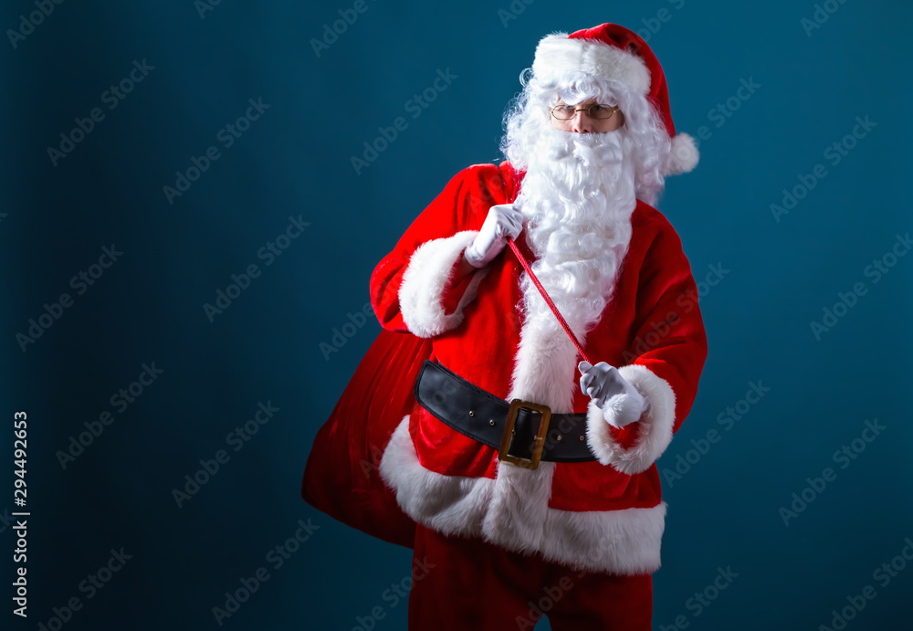 Santa holding a red sack on a dark blue background