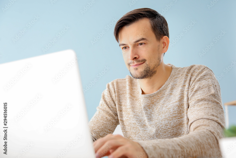 Handsome man working on laptop at home