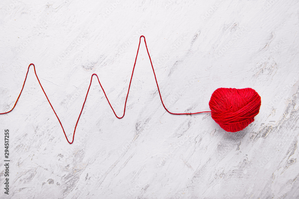 Composition with heart and cardiogram made of thread on light background