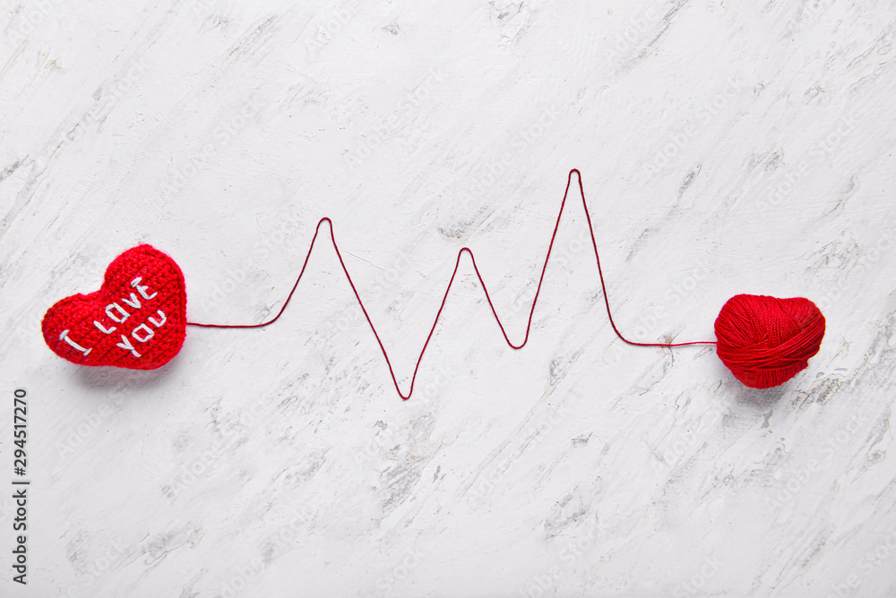 Composition with hearts and cardiogram made of thread on light background