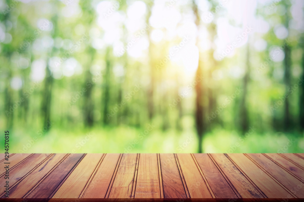 empty wood table on blur forest background for design product