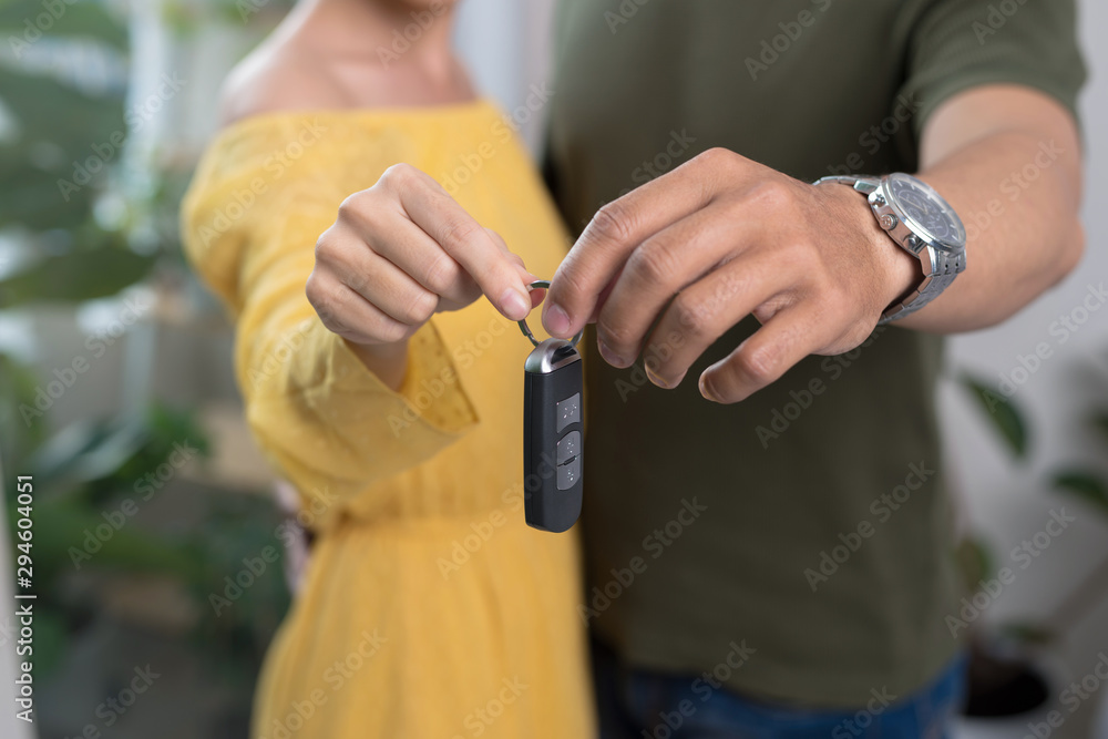 Young couple holding up new car key