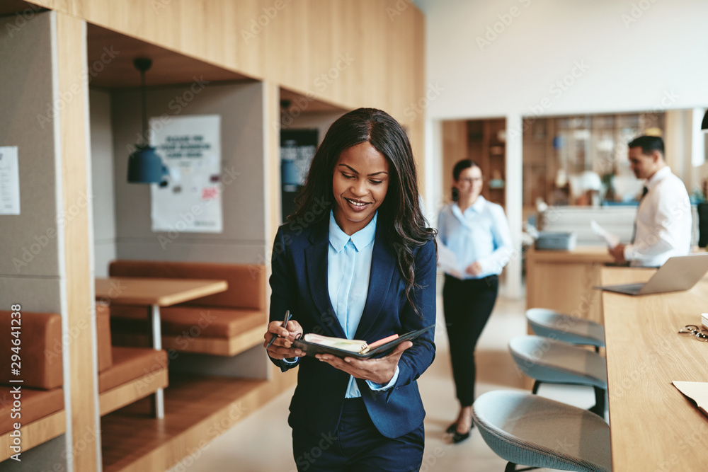 Smiling African American businesswoman walking through an office