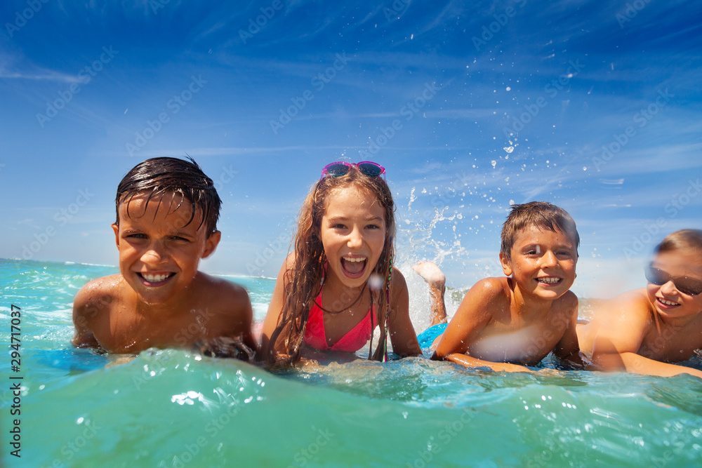 Group of kids lay in sea water swim and splah