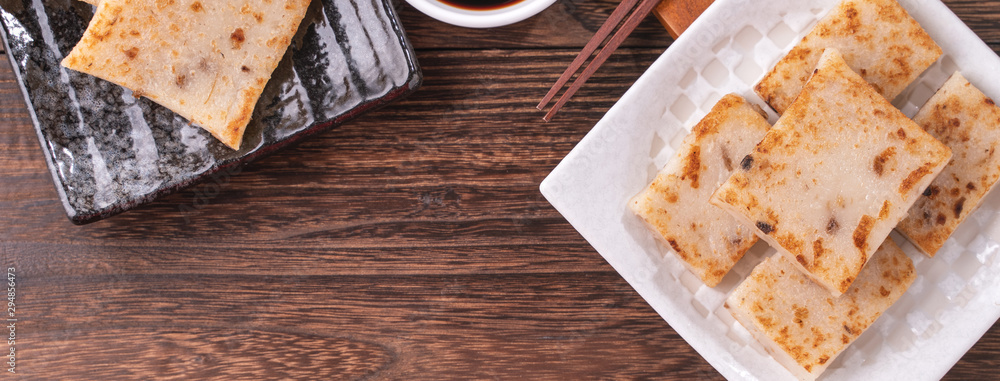 Delicious turnip cake, Chinese traditional local radish cake in restaurant with soy sauce and chopst