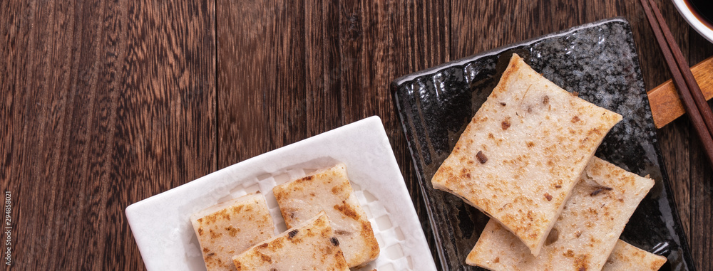 Delicious turnip cake, Chinese traditional local radish cake in restaurant with soy sauce and chopst