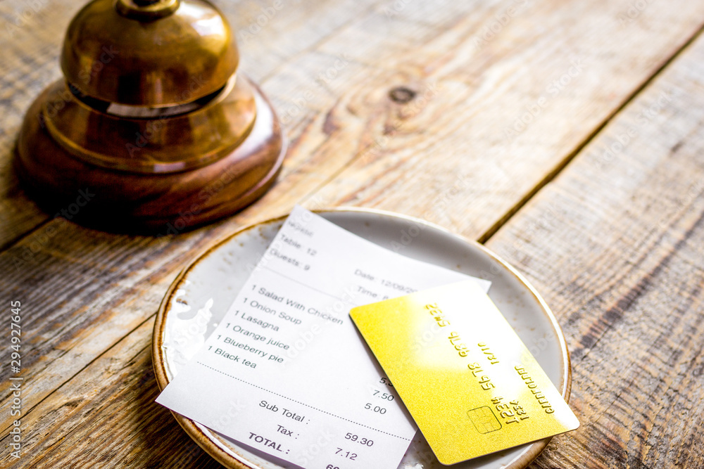 plate and receipt bill for payment by credit card wooden table background