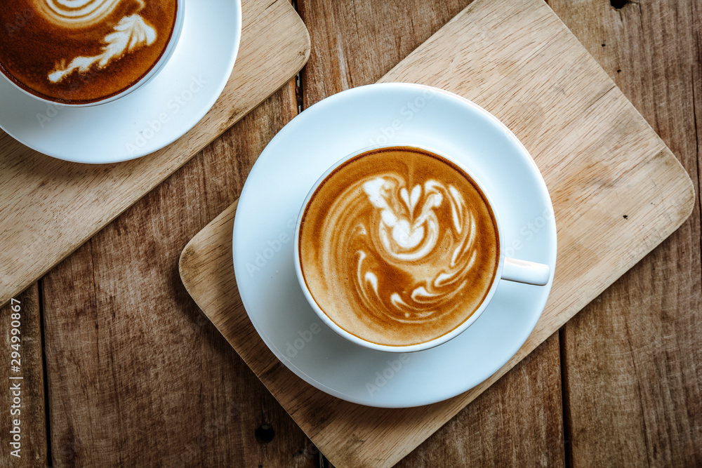 cup of hot latte art coffee on wooden table