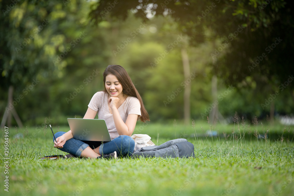 Confident smiling pretty young woman sitting on workplace in outdoor with laptop. Working concept