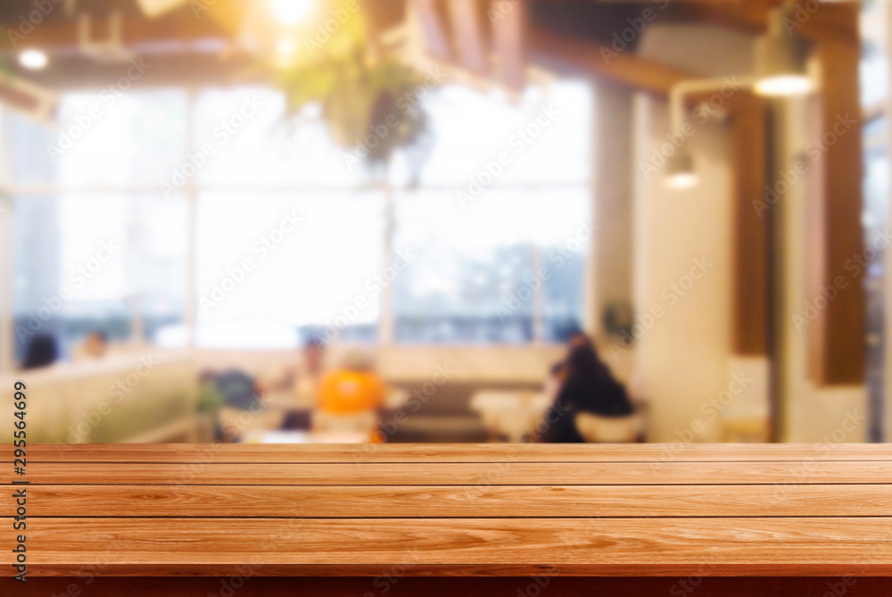 Wood table in blurry background of modern restaurant room or coffee shop with empty copy space on th