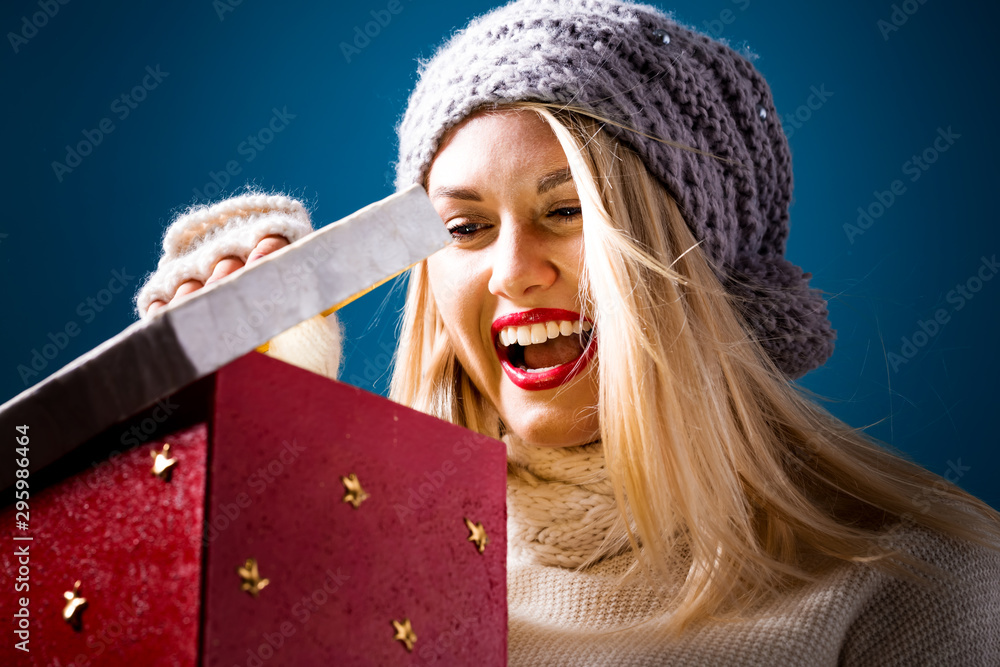 Happy young woman opening a Christmas present box