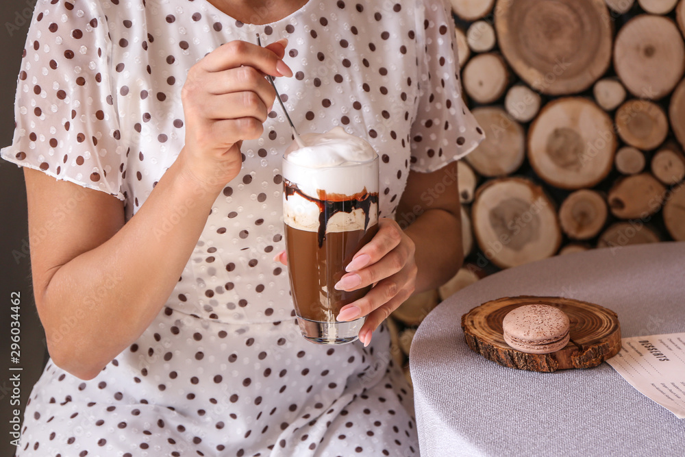 Woman drinking tasty frappe coffee in cafe