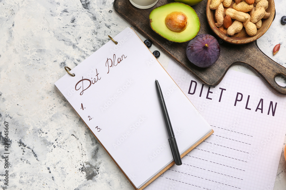 Notebook with diet plan and healthy products on white table