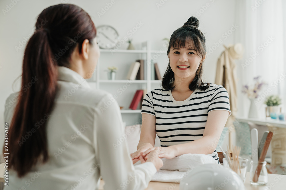 美丽年轻的亚洲韩国女性在美甲服务中修指甲的照片。剪得很开心